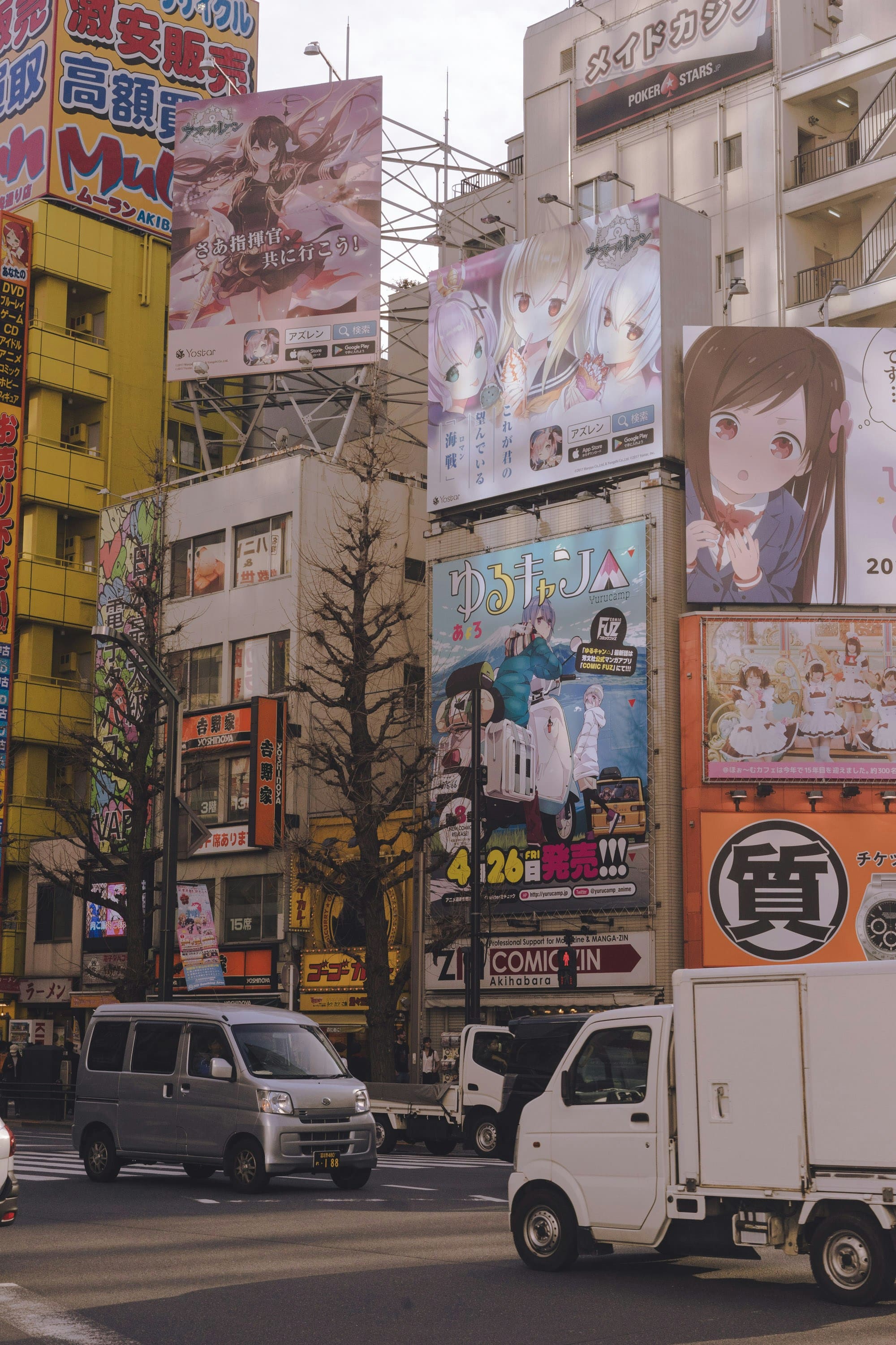 Daytime Akihabara Japan street scene with anime billboards and traffic